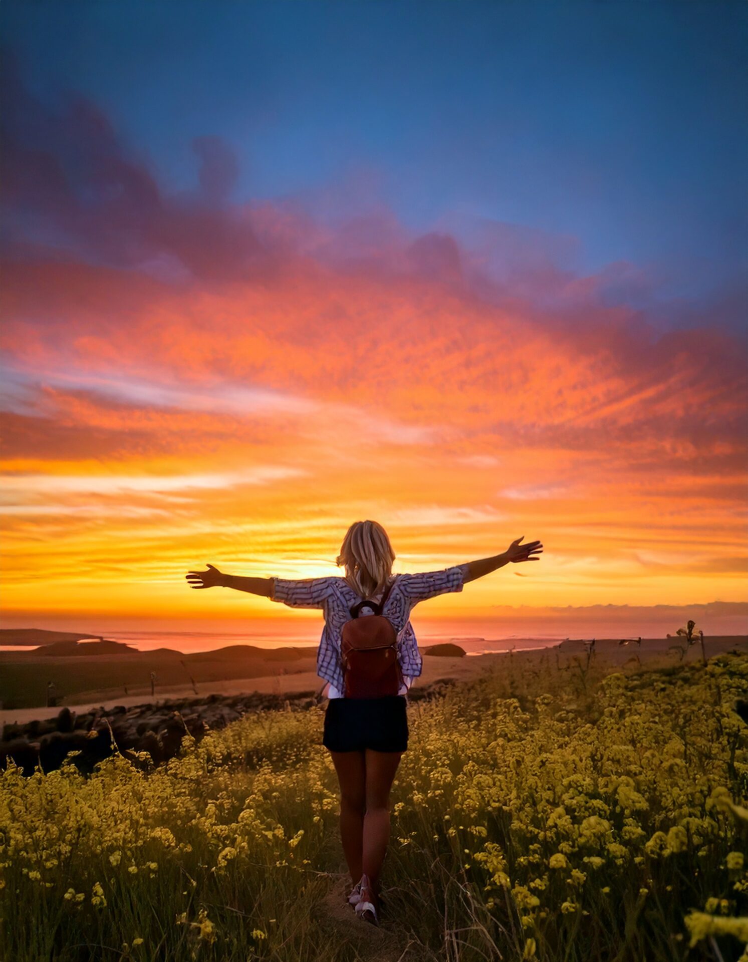 Firefly a blonde woman in her 50s enjoying walking into a colorful sunset with her arms wide open. t